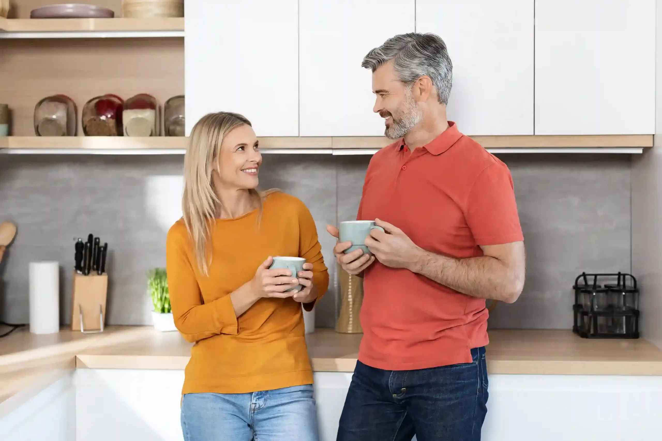 couples-coaching-workshop Mature couple sharing a warm moment in the kitchen after a marital relationship counseling session with Marriage Helper.