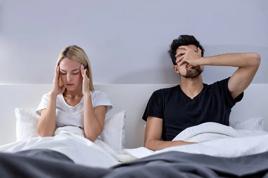 A frustrated couple in bed after the wife sexually rejected her husband. Get help fix your relationship with Marriage Helper